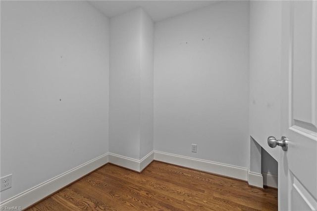 empty room featuring wood finished floors and baseboards