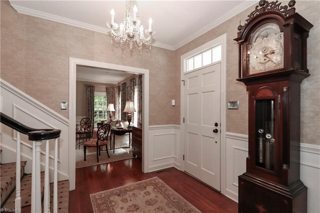 foyer entrance with crown molding, a notable chandelier, and dark hardwood / wood-style floors