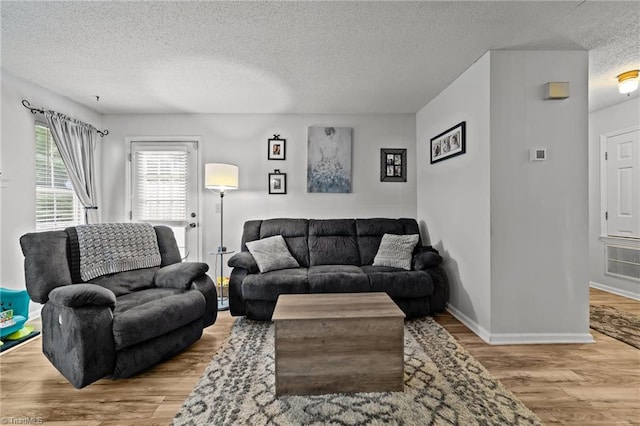 living room with light hardwood / wood-style flooring and a textured ceiling