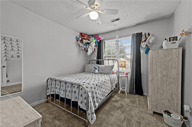 carpeted bedroom with a textured ceiling and ceiling fan