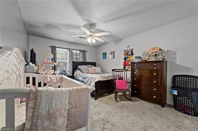 carpeted bedroom featuring a textured ceiling and ceiling fan