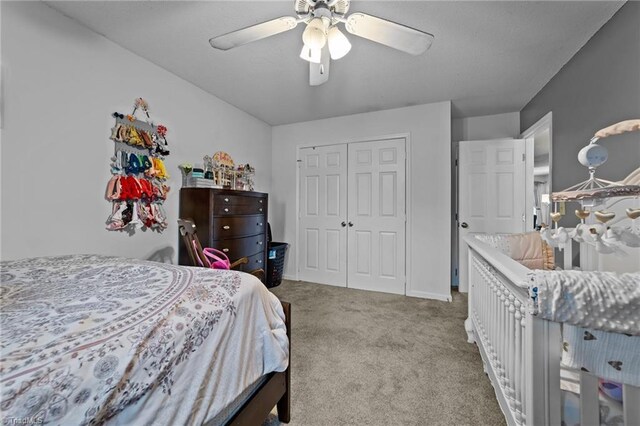 bedroom featuring ceiling fan, light carpet, and a closet