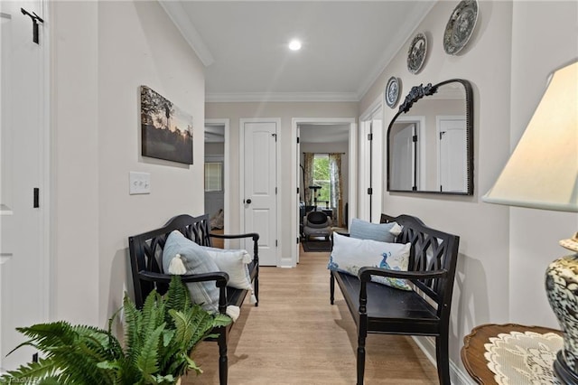 living area featuring crown molding and light hardwood / wood-style floors