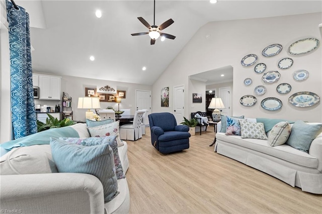 living room with light wood-type flooring, ceiling fan, and high vaulted ceiling