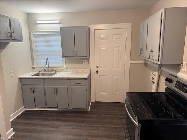 kitchen featuring dark hardwood / wood-style floors, gray cabinets, sink, and stainless steel range with electric cooktop