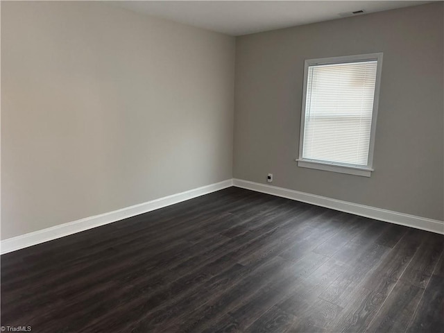 unfurnished room with dark wood-type flooring