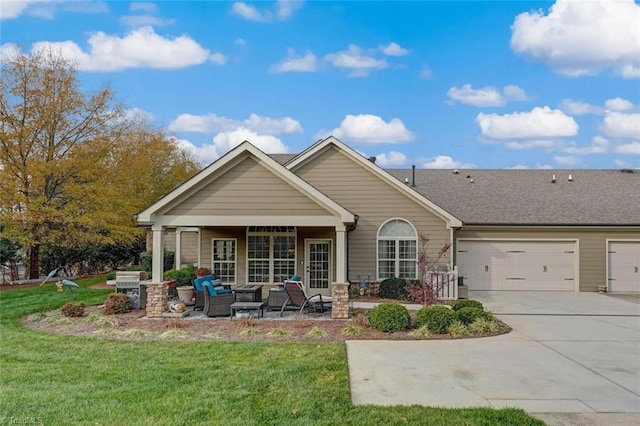 back of house with a lawn, outdoor lounge area, and a garage