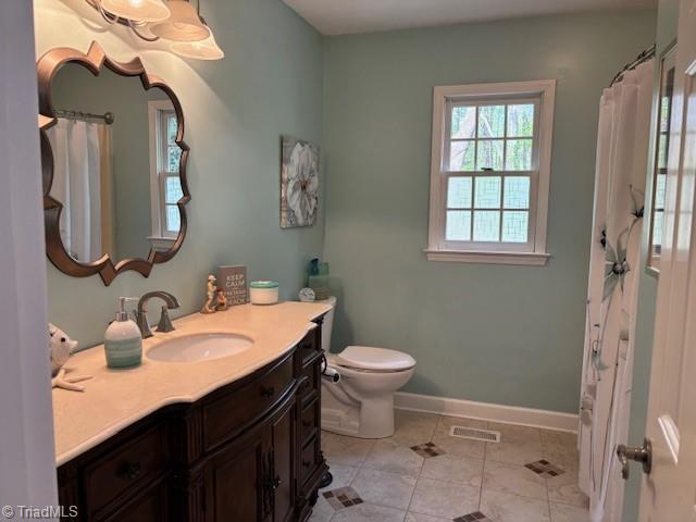 bathroom featuring visible vents, tile patterned flooring, vanity, baseboards, and toilet