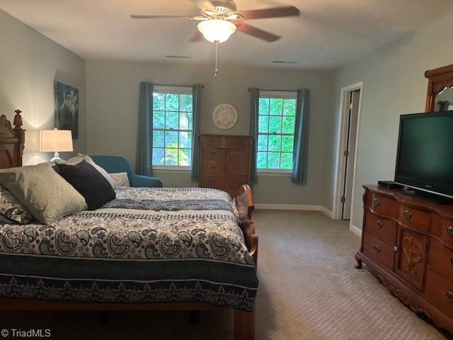 bedroom featuring baseboards, light carpet, and a ceiling fan