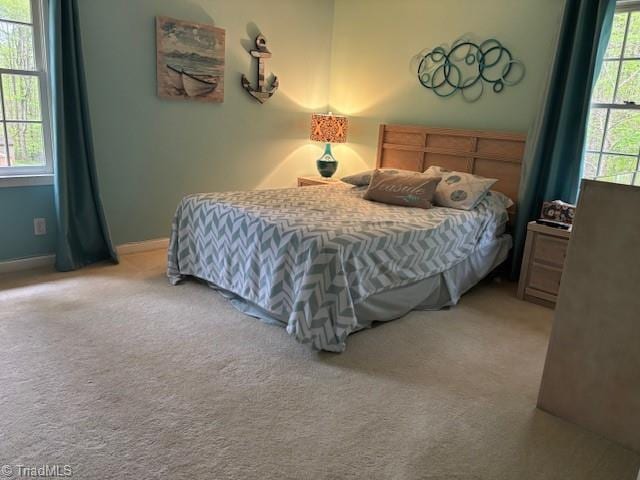 bedroom with baseboards and light carpet
