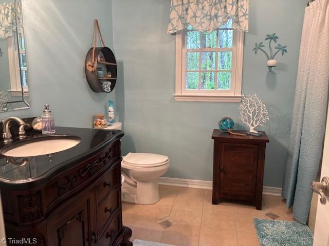 full bath with vanity, baseboards, toilet, and tile patterned floors