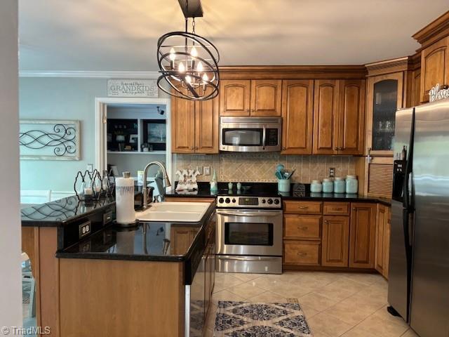 kitchen featuring brown cabinetry, a sink, appliances with stainless steel finishes, and backsplash