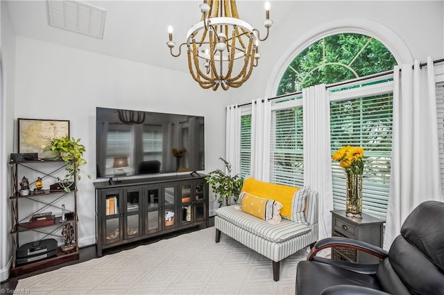 living area featuring visible vents and a notable chandelier