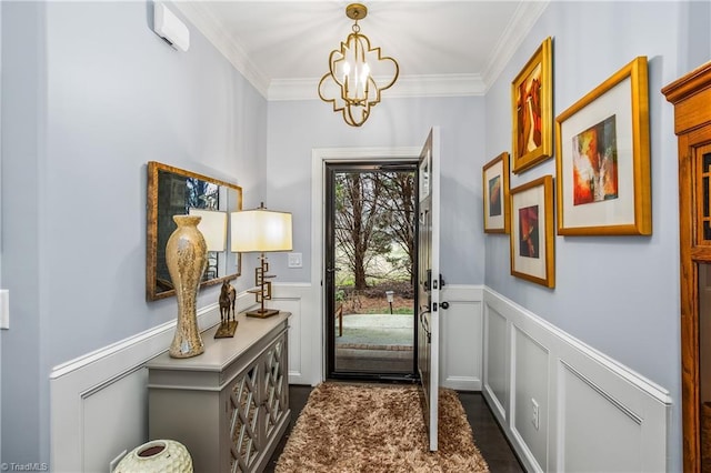 doorway to outside with ornamental molding, a chandelier, wainscoting, and a decorative wall