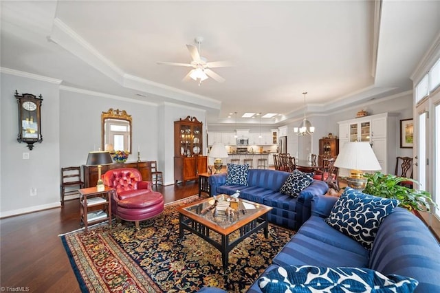 5905 Knowledge Dr, Clemmons, NC 27012 - living room featuring a raised ceiling, dark wood-style floors, ceiling fan, a chandelier, and crown molding