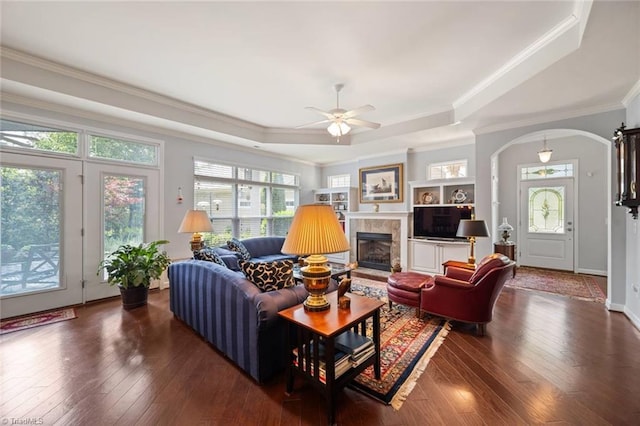 5905 Knowledge Dr, Clemmons, NC 27012 - living room featuring arched walkways, a tray ceiling, ornamental molding, ceiling fan, and a tiled fireplace