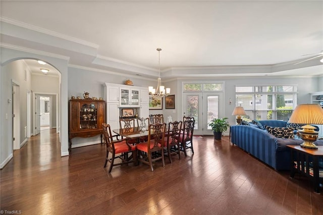5905 Knowledge Dr, Clemmons, NC 27012 - dining room with a tray ceiling, arched walkways, dark wood-style floors, a chandelier, and ornamental molding