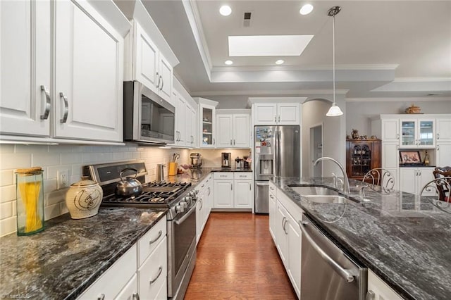 5905 Knowledge Dr, Clemmons, NC 27012 - kitchen with stainless steel appliances, a sink, a skylight, white cabinets, and glass insert cabinets