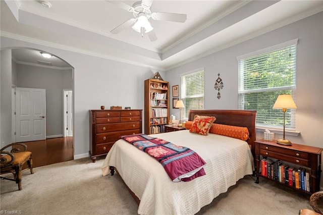 5905 Knowledge Dr, Clemmons, NC 27012 - carpeted bedroom with arched walkways, a raised ceiling, crown molding, a ceiling fan, and baseboards