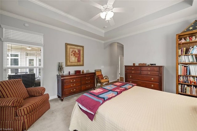 5905 Knowledge Dr, Clemmons, NC 27012 - bedroom featuring a tray ceiling, arched walkways, light carpet, crown molding, and baseboards