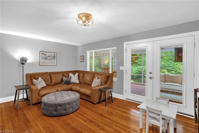 living room featuring wood finished floors, baseboards, and french doors
