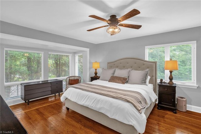 bedroom featuring wood finished floors, baseboards, and a ceiling fan