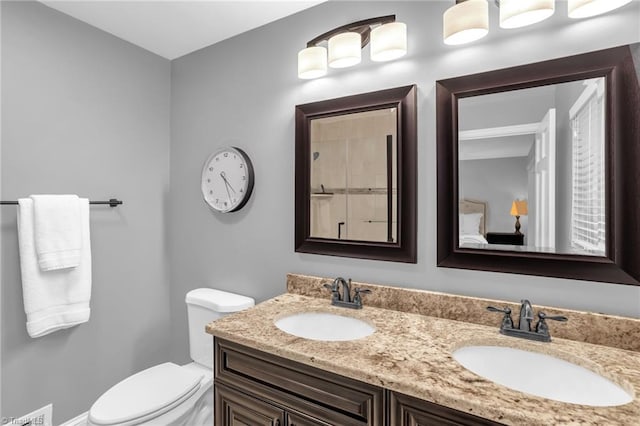 bathroom with toilet and double vanity