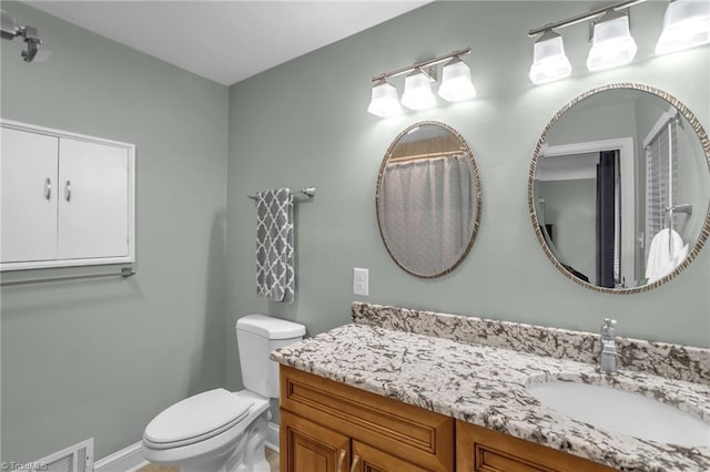 full bathroom featuring toilet, vanity, and baseboards