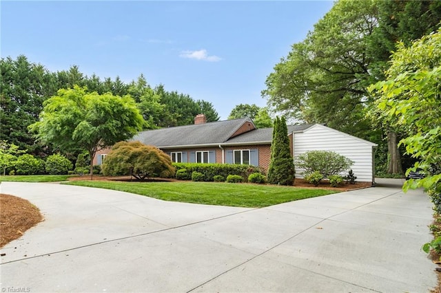 view of front of home with a front lawn, driveway, and brick siding