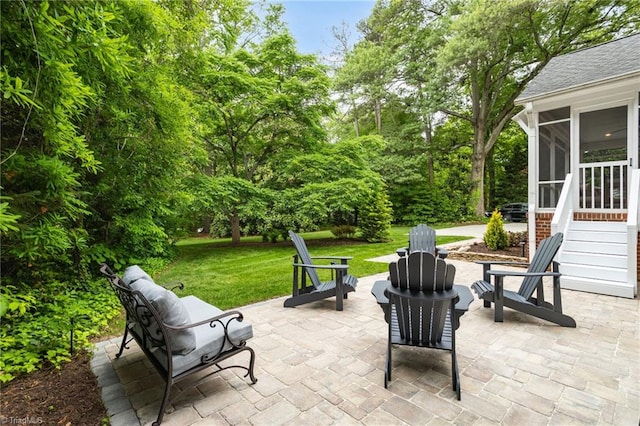 view of patio featuring a sunroom and a fire pit