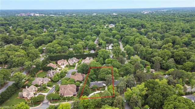 aerial view of property and surrounding area featuring property parcel outlined and a forest