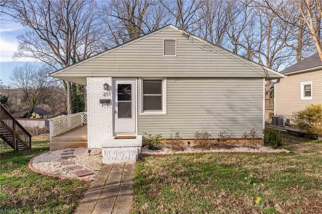 view of front of property with central AC and a front lawn