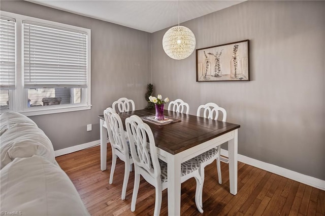 dining room with hardwood / wood-style floors and a notable chandelier