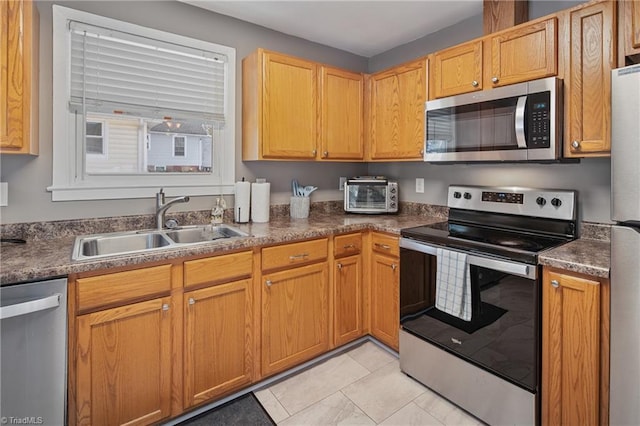 kitchen with stainless steel appliances, light tile patterned flooring, and sink