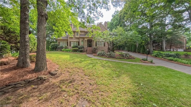 1005 Fallbrook Ln, Lewisville, NC 27023 - view of front of house with a front lawn, a chimney, and driveway