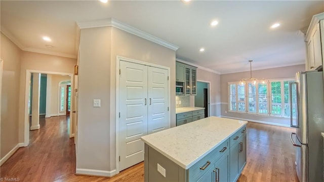 1005 Fallbrook Ln, Lewisville, NC 27023 - kitchen with appliances with stainless steel finishes, a center island, light wood-style flooring, baseboards, and ornamental molding