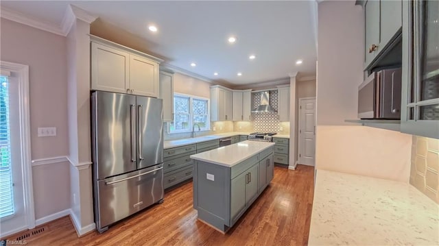 1005 Fallbrook Ln, Lewisville, NC 27023 - kitchen with appliances with stainless steel finishes, ornamental molding, wall chimney range hood, light countertops, and decorative backsplash