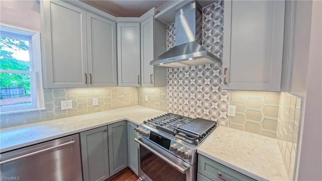 1005 Fallbrook Ln, Lewisville, NC 27023 - kitchen with stainless steel appliances, wall chimney range hood, gray cabinetry, and decorative backsplash