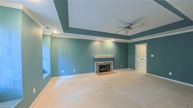 1005 Fallbrook Ln, Lewisville, NC 27023 - unfurnished living room featuring a tray ceiling, a fireplace with flush hearth, ceiling fan, ornamental molding, and carpet
