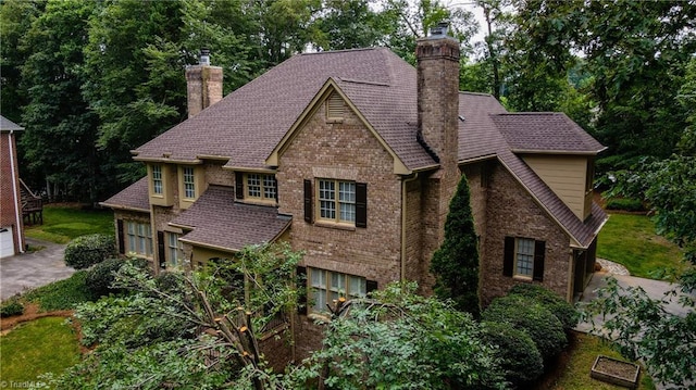 1005 Fallbrook Ln, Lewisville, NC 27023 - view of front of house featuring a chimney, brick siding, and a garage