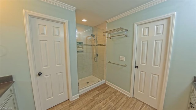 1005 Fallbrook Ln, Lewisville, NC 27023 - bathroom featuring vanity, a stall shower, baseboards, crown molding, and wood finished floors