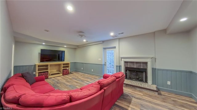 1005 Fallbrook Ln, Lewisville, NC 27023 - living room featuring a wainscoted wall, wood finished floors, a tiled fireplace, and recessed lighting