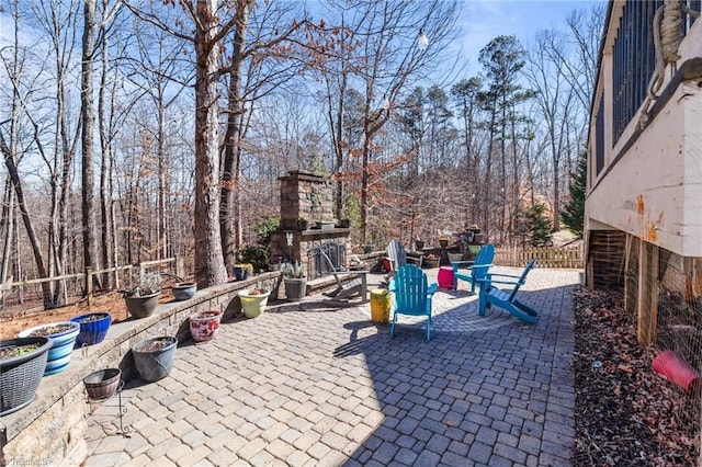 view of patio / terrace featuring an outdoor stone fireplace and fence