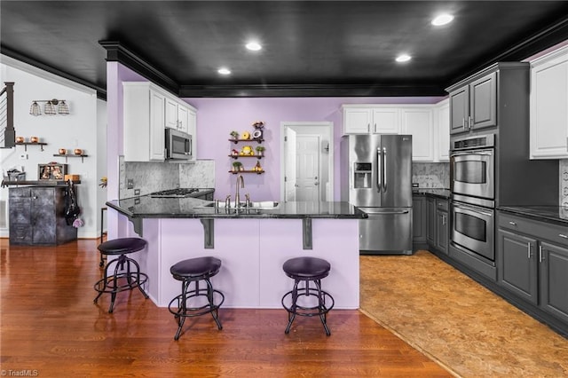 kitchen with white cabinetry, appliances with stainless steel finishes, a sink, and gray cabinetry