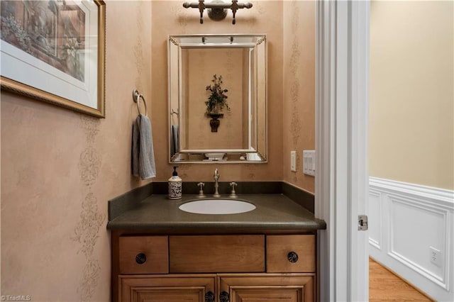 344 Lake Point Ln, Belews Creek, NC 27009 - bathroom with vanity, wallpapered walls, wood finished floors, and a wainscoted wall