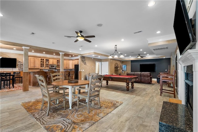 344 Lake Point Ln, Belews Creek, NC 27009 - dining space featuring a ceiling fan, decorative columns, a fireplace, light wood-style flooring, and ornamental molding
