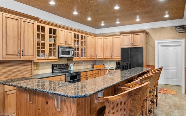 344 Lake Point Ln, Belews Creek, NC 27009 - kitchen with appliances with stainless steel finishes, ornamental molding, a kitchen breakfast bar, glass insert cabinets, and tasteful backsplash