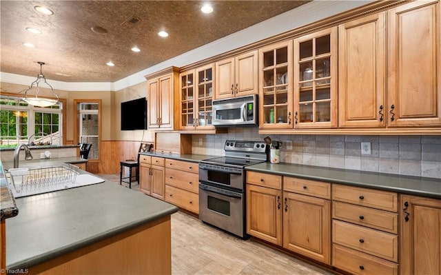 344 Lake Point Ln, Belews Creek, NC 27009 - kitchen featuring appliances with stainless steel finishes, ornamental molding, dark countertops, wainscoting, and glass insert cabinets