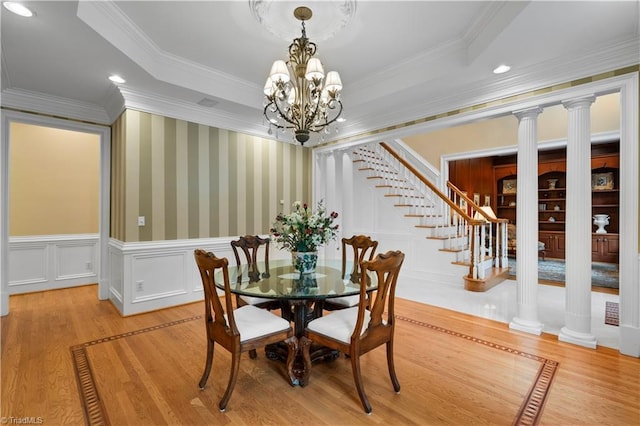 344 Lake Point Ln, Belews Creek, NC 27009 - dining space featuring wood finished floors, stairs, a chandelier, wainscoting, and ornamental molding