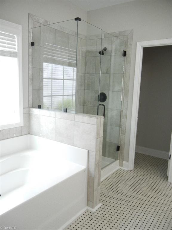715 Cannonade Dr, Whitsett, NC 27377 - bathroom featuring a bath and a stall shower